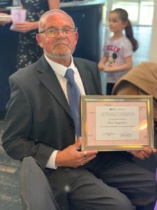 Rae Augustin holding his award.