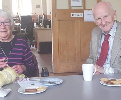 Service users enjoying a hot drink and biscuits.