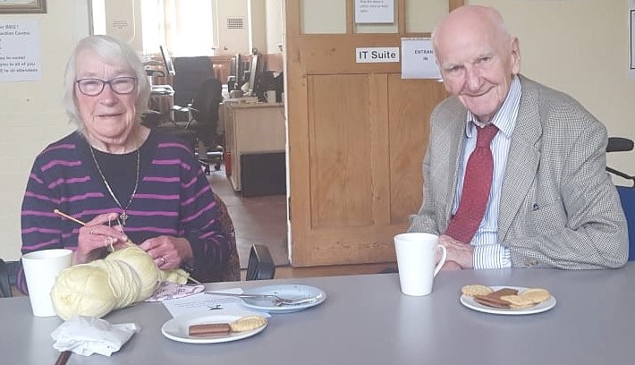 Service users enjoying a hot drink and biscuits.